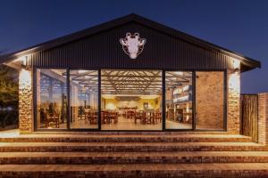 un restaurante con grandes ventanas de cristal y escaleras en Windhoek Game Camp en Lafrenz Township