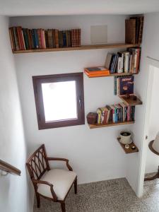 a room with a chair and a window and books at Casa Nueva in Jimena de la Frontera