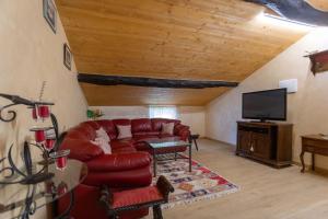 Una sala de estar con un sofá rojo y un televisor de pantalla plana. en Casa Vacanze Mon Rêve, en Cavalcaselle