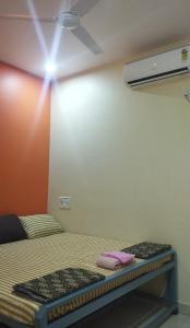 Cette chambre dispose d'un lit avec une lumière sur le mur. dans l'établissement आंगण होम स्टे, à Malvan