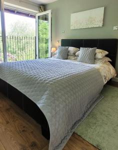 a large bed in a bedroom with a large window at Kingsley Cottage in Beaworthy +16 photos