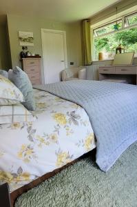 a bedroom with a large bed with a blanket at Kingsley Cottage Bed & Breakfast in Beaworthy
