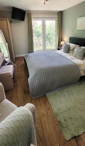 a bedroom with two beds and a large window at Kingsley Cottage in Beaworthy