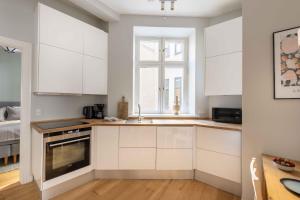 a kitchen with white cabinets and a window at Stylish Flat at Best Location in CPH by The Canals in Copenhagen