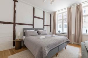 a bedroom with a large bed and two windows at Stylish Apartment at Best Location in CPH by The Canals in Copenhagen