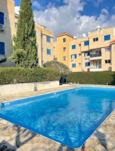 einem blauen Pool vor einem Gebäude in der Unterkunft Pafia A in Paphos City