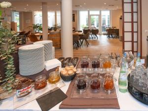 a table with plates and jars of food on it at Hotel Bargenturm in Lüneburg