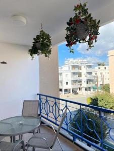 ein Balkon mit Tisch und Stühlen und ein Gebäude in der Unterkunft Pafia A in Paphos City