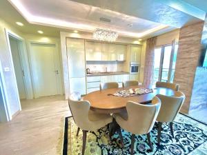 Blue Marlin Apartments في بودفا: غرفة طعام مع طاولة وكراسي خشبية
