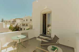 a balcony with a table and chairs and a window at Opal Paros in Naousa