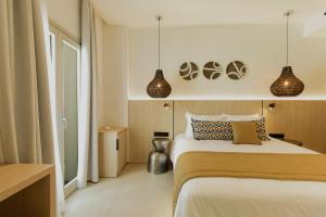 a bedroom with a bed and two pendant lights at Opal Paros in Naousa