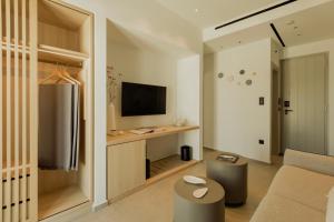 a living room with a couch and a television at Opal Paros in Naousa