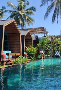 a woman standing in the water in a swimming pool at Absolute Villa in Gili Trawangan