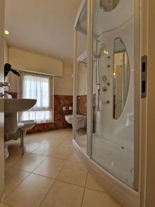 y baño con ducha y lavamanos. en Hotel Villa Anthea, en Garda