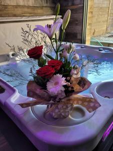 HORIZON SPA في Samer: إناء من الزهور جالس على طاولة