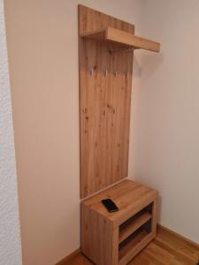 ein Holzregal in einer Ecke eines Zimmers in der Unterkunft Ferienwohnung Sternenblick in Schönau im Schwarzwald