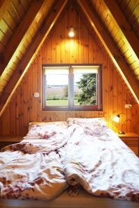 uma cama grande num quarto com uma janela em The Rainbow - Domki Letniskowe em Dźwirzyno