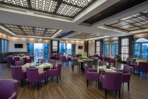 a dining room with tables and purple chairs at Corp Amman Hotel in Amman