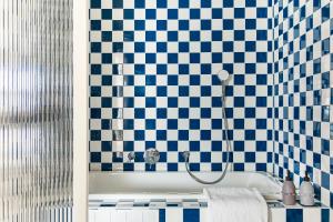 赫爾辛基的住宿－Hobo Helsinki，浴室配有蓝色和白色瓷砖的浴缸