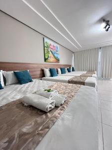 a row of beds in a room at Hotel Cantinho Verde in Teixeira de Freitas
