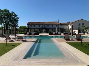 une piscine avec des chaises et une maison en arrière-plan dans l'établissement Agriturismo Zapparè Farm Hotel, à Trevignano