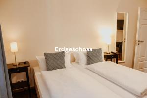 een wit bed in een kamer met 2 lampen bij Alte Münze Apartments in Goslar