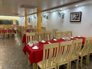 a dining room with tables and chairs with red table cloth at Thu Hoai Hotel in Cat Ba