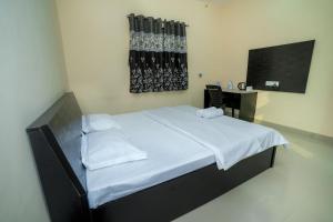 a bedroom with a large bed with white sheets at Paradise Homestay in Pune