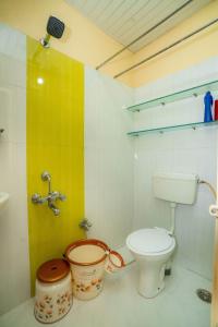 a bathroom with a toilet and a bucket in it at Paradise Homestay in Pune