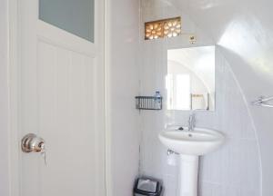 uma casa de banho branca com um lavatório e um espelho em Rainbow Glamping em Padangan