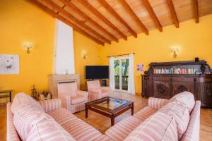 een woonkamer met een bank, stoelen en een tafel bij Villa Ensueño in Cala Ratjada
