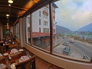 una grande finestra in un ristorante con vista su una strada di Asura hotel a Thimphu