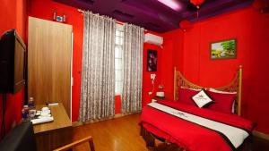 ハノイにあるPhuong Dong hotelの赤い壁のベッドルーム1室、赤いシーツ付きのベッド1台が備わります。
