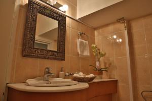 a bathroom with a sink and a mirror at Sofouli Suites in Nicosia