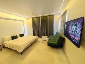 Un dormitorio con una cama, un televisor y una silla. en Ridge House for 4-10 PAX, en Mount Abu 32 fotos más