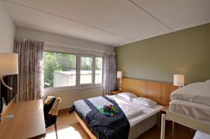 a bedroom with a bed and a window at Scandic Aarhus Vest in Aarhus