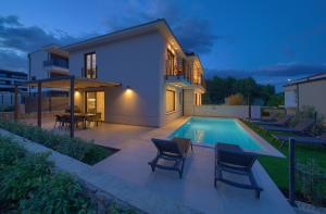 a villa with a swimming pool at night at New villa with pool, sea view, close to a beautiful beach - By TRAVELER tourist agency Krk - ID 2407 in Krk