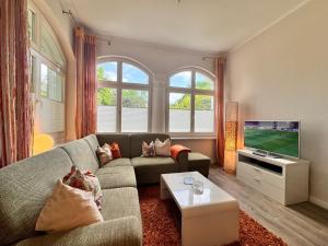 een woonkamer met een bank en een flatscreen-tv bij Villa Aegir 103 in Neuhof