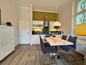 een keuken en eetkamer met een tafel en stoelen bij Villa Aegir 103 in Neuhof