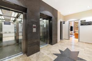 um corredor com portas de vidro e pisos em azulejo em Mayar Residence Hotel em Istambul