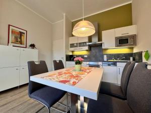 een keuken met een eettafel en stoelen bij Villa Aegir 103 in Neuhof
