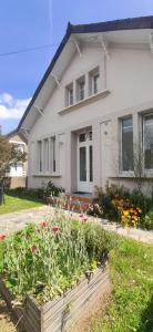 a house with a flower bed in front of it at Villa des roses, comme à la maison in Cherbourg en Cotentin