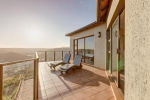 a balcony with two chairs on top of a house at Garden Route Ilita Lodge in Groot Brak Rivier