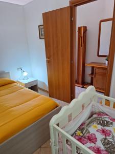 a bedroom with a bed and a wooden cabinet at Casa vacanze Bouganville in Gonnosfanàdiga