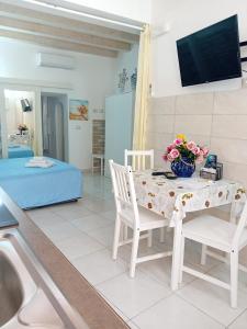 a kitchen and living room with a table and chairs at Casa Rosa Apartments Ortgia in Siracusa