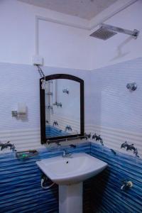 a bathroom with a sink and a mirror at Sri Shahrukh Lake Resort in Tissamaharama