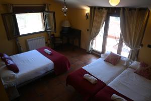 um quarto de hotel com duas camas e uma janela em De Felipe Casa Rural em Horche