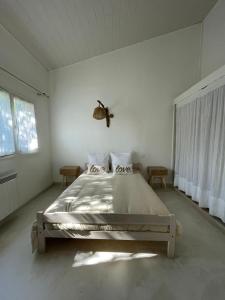 a bedroom with a large bed in a white room at A CASA DI SPIAGGIA in San-Nicolao