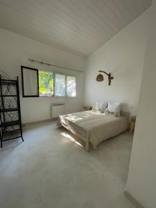 a bedroom with a bed in a white room at A CASA DI SPIAGGIA in San-Nicolao