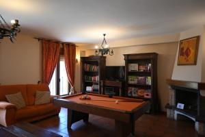 uma sala de estar com uma mesa de bilhar e um sofá em De Felipe Casa Rural em Horche